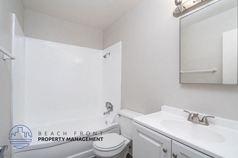 a white bathroom with a sink and toilet and a mirror